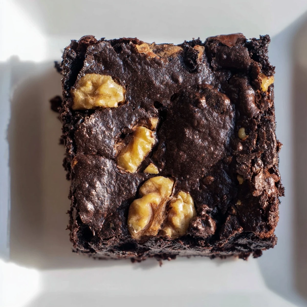 A freshly baked batch of Chocolate Fudge Brownies with Walnuts cooling on a rack, rich brown edges and glossy chocolate chips visible.