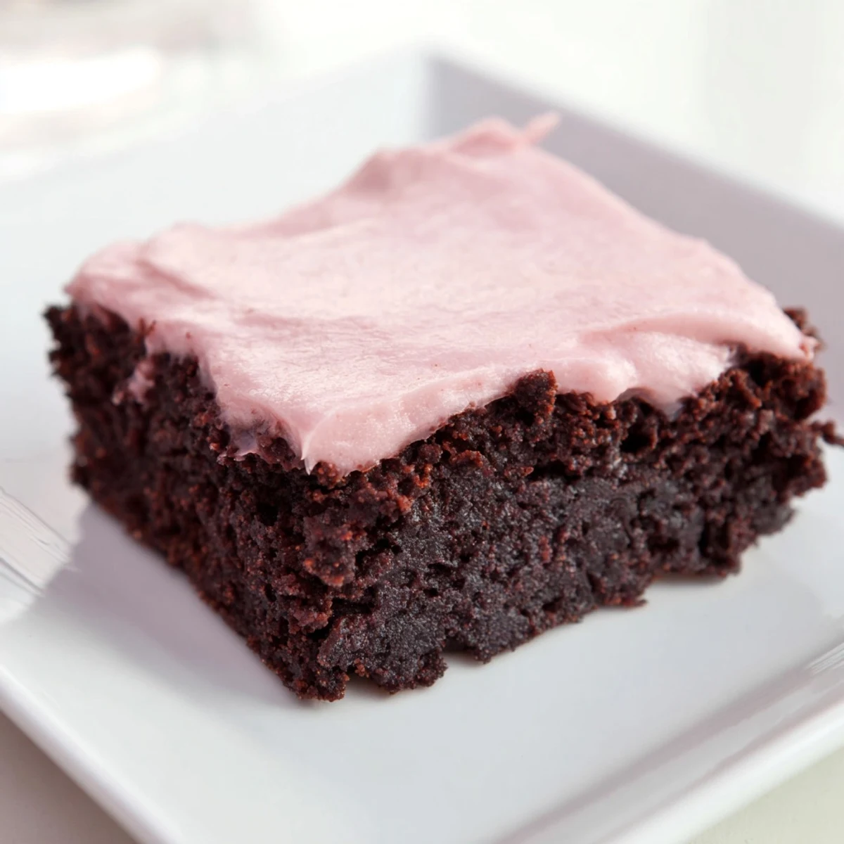 A close-up view shows a square of Brownies with Pink Frosting and moist crumbs, ideal for an indulgent treat.