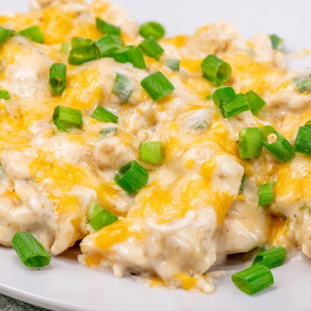 A serving of Sour Cream and Onion Chicken paired with steamed broccoli and buttery mashed potatoes on a rustic plate.
