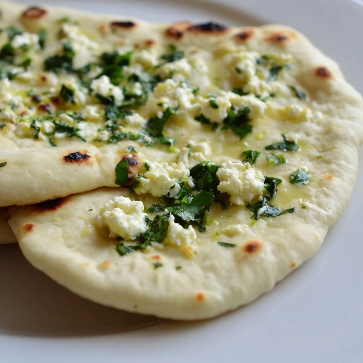 Soft Cottage Cheese Garlic Naan split open to reveal creamy cottage cheese filling studded with green chili.