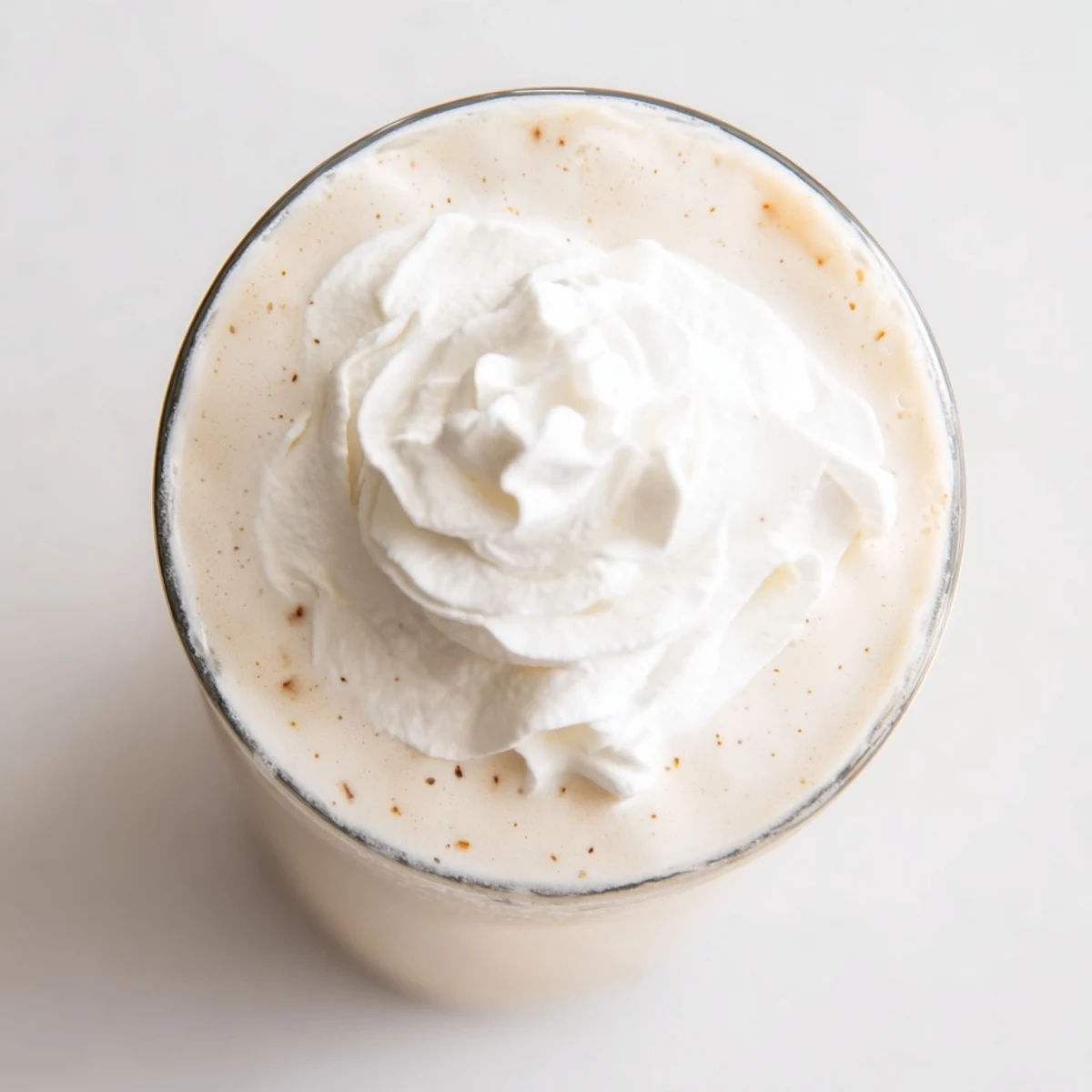 Creamy Starbucks Vanilla Bean Frappuccino topped with whipped cream in a tall glass.