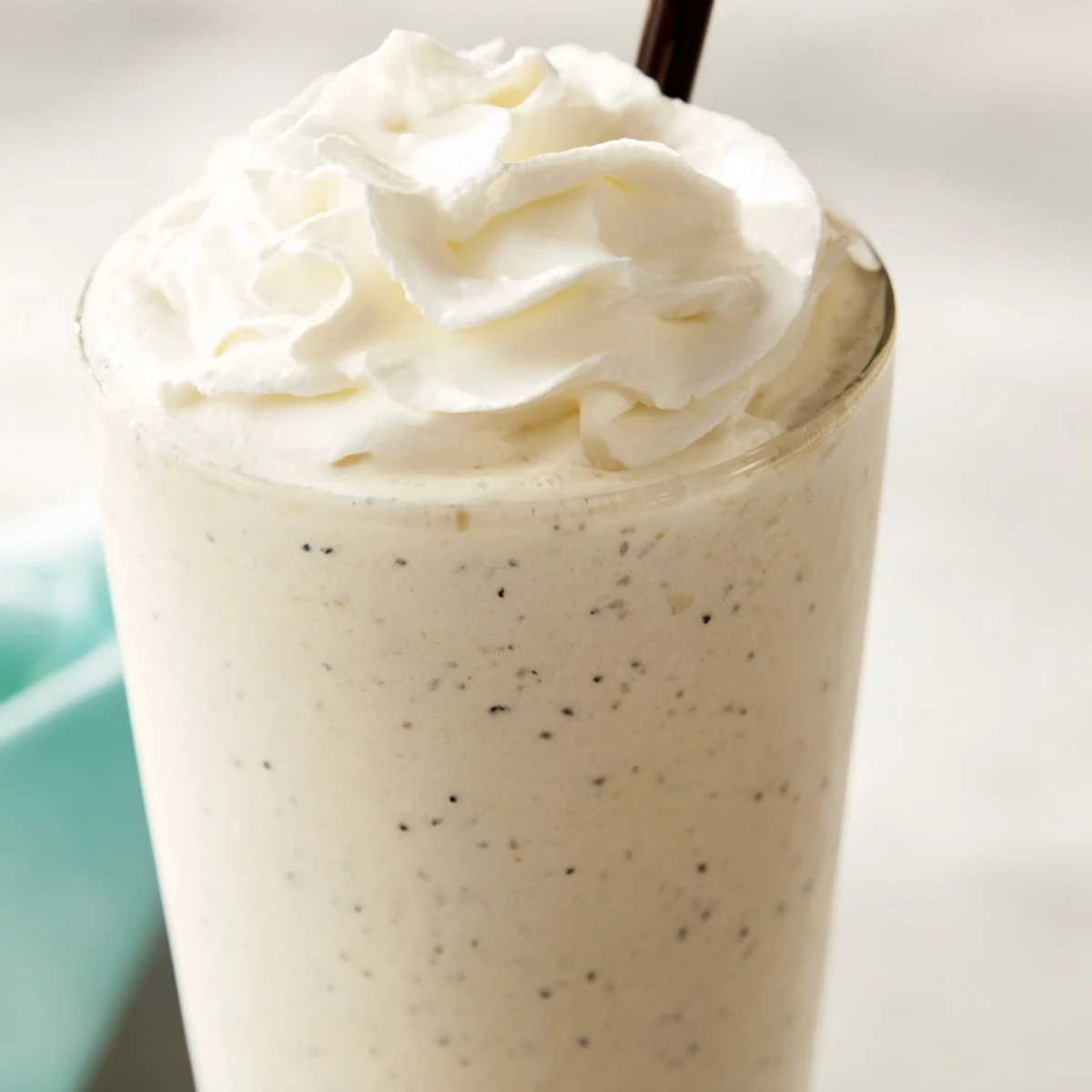A frosty Vanilla Bean Frappuccino garnished with whipped cream and vanilla bean specks perfect for a summer treat.