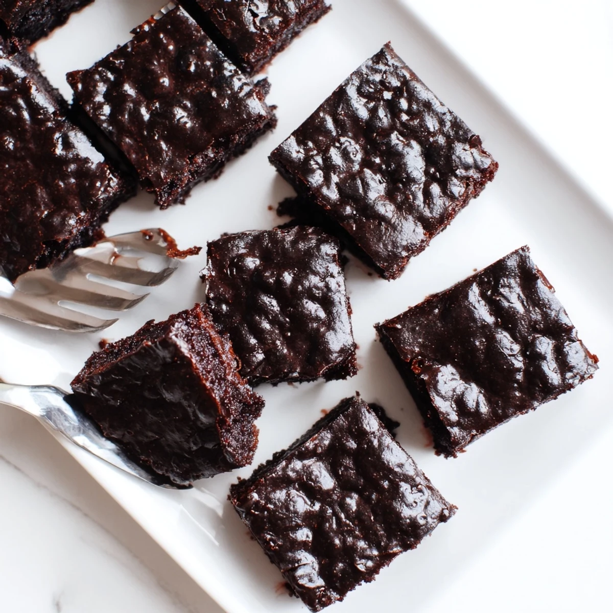 Freshly baked Fudgy Brown Butter Mochi Brownies showcase a shiny, crackled top and rich chocolate color. 