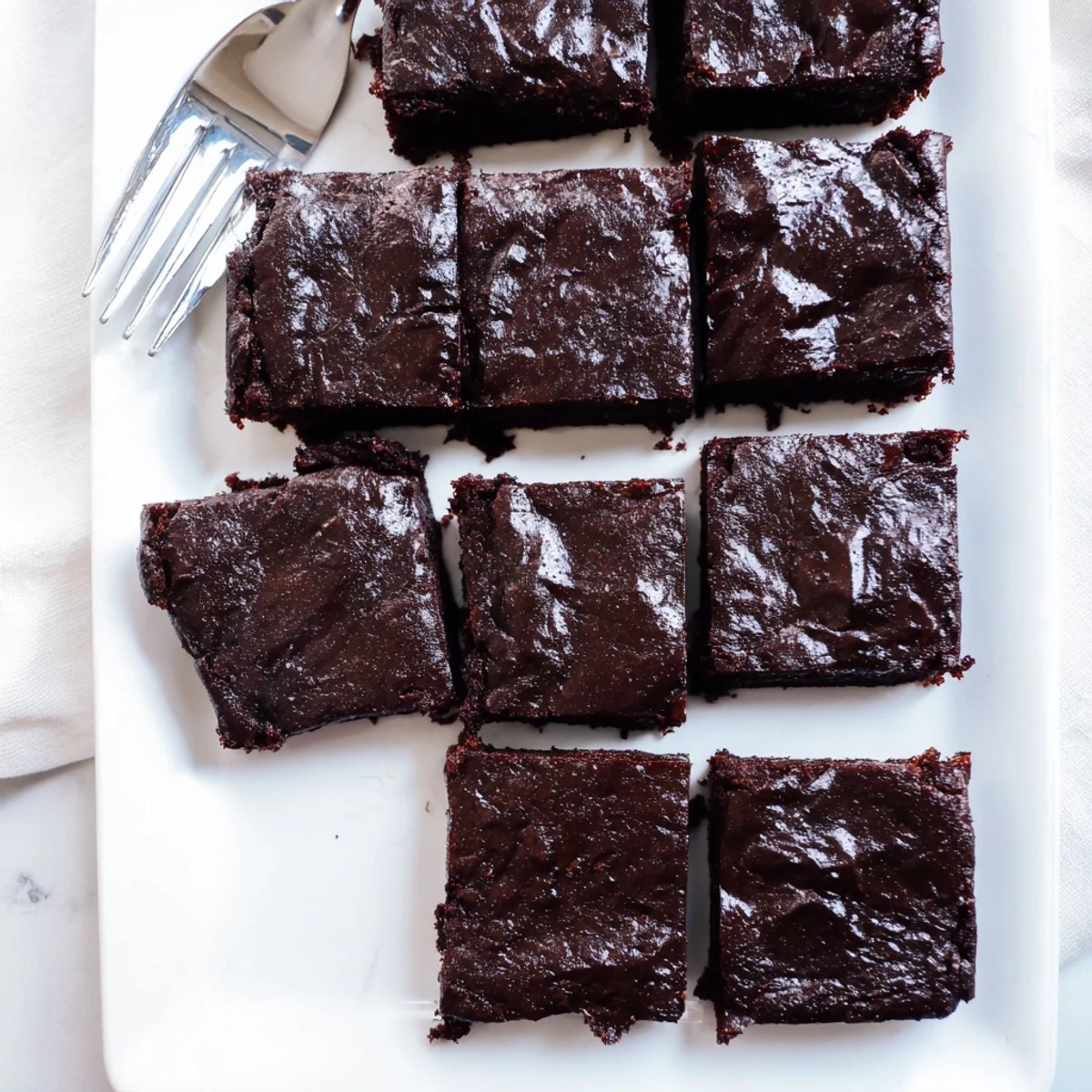 A close-up of Fudgy Brown Butter Mochi Brownies highlights a dense, fudgy interior studded with melted chocolate chips.