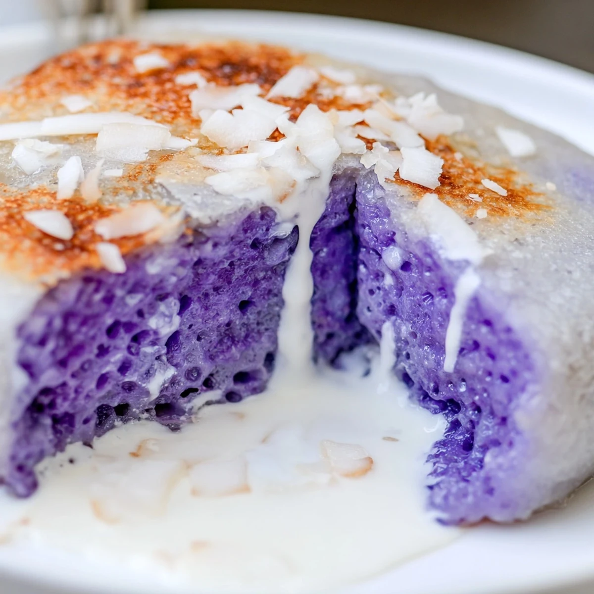 Golden-brown Ube Mochi Pancakes sizzle on a griddle, their sticky mochi batter promising a delightfully chewy breakfast treat.