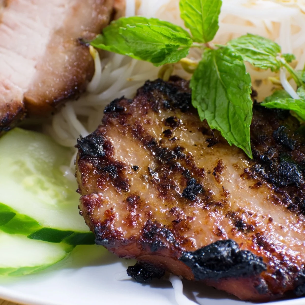 Tangy Nuoc Cham sauce drizzled over Bun Cha Hanoi with crisp lettuce and bean sprouts.