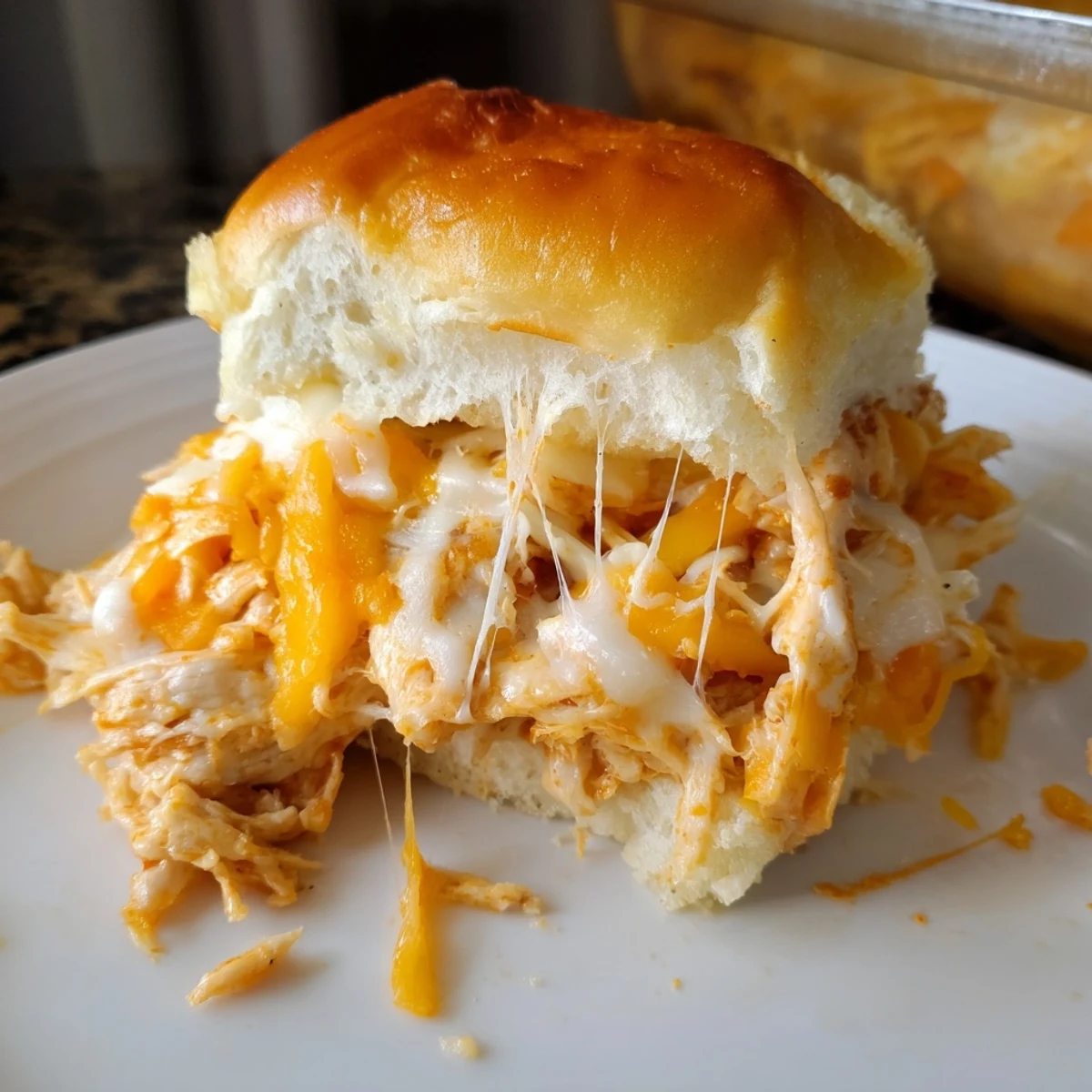 Golden Buffalo Chicken Pizza Dip Sliders bubbling with melted mozzarella and cheddar on soft Hawaiian rolls.