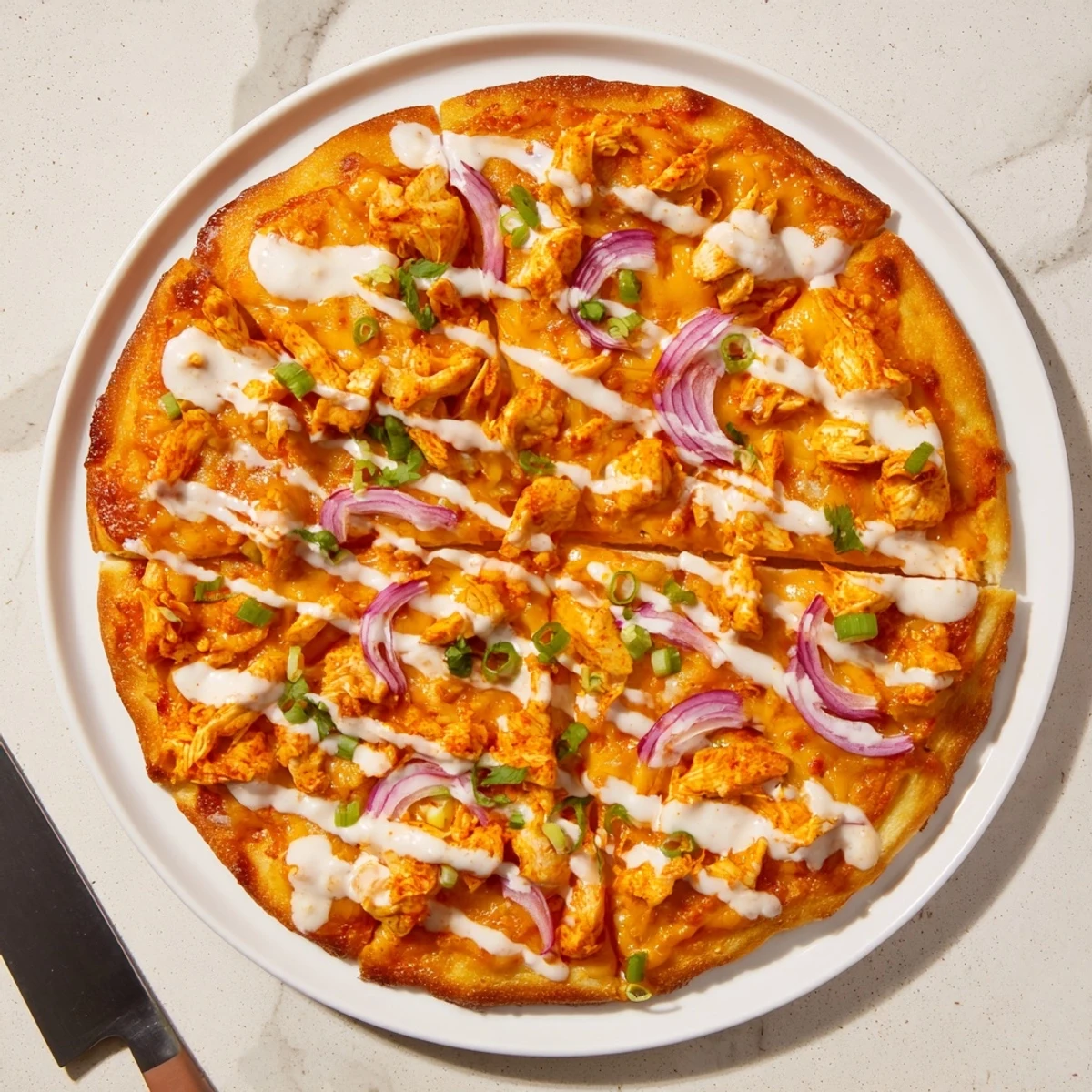 A close-up of Bold Buffalo Chicken Pizza showing shredded buffalo chicken, creamy ranch base, and a golden crispy crust.