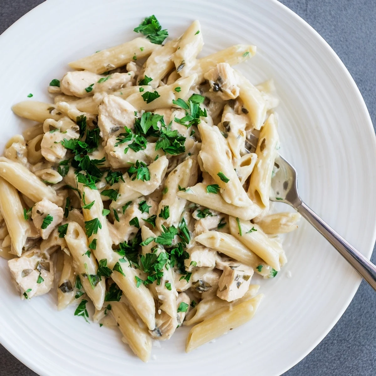 Comforting Crockpot Garlic Parmesan Chicken Pasta served hot in a bowl, ready for a busy weeknight dinner with family.