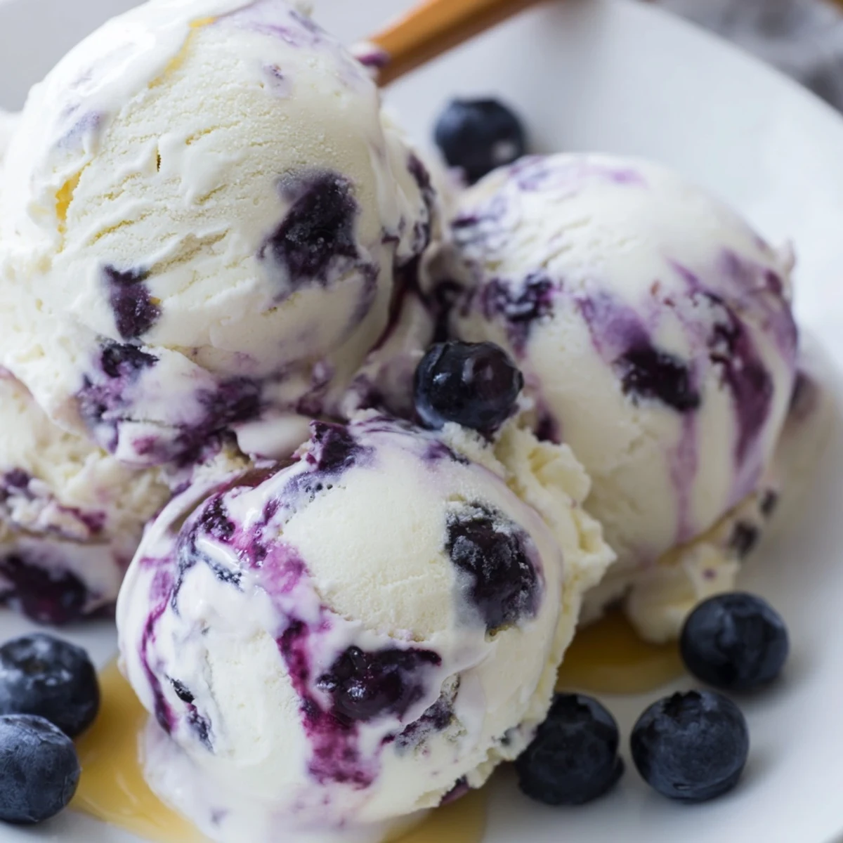 Creamy Blueberry Cottage Cheese Ice Cream scoops beautifully in a pastel bowl, topped with fresh blueberries and a honey drizzle.
