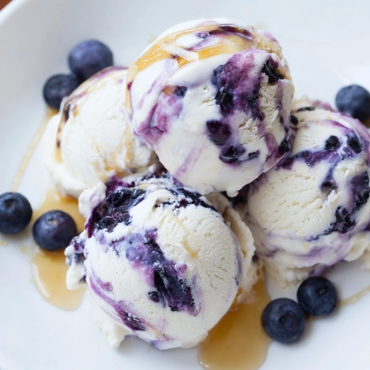 Homemade Blueberry Cottage Cheese Ice Cream served in a cone, with vibrant blueberries and a mint garnish for summer enjoyment.