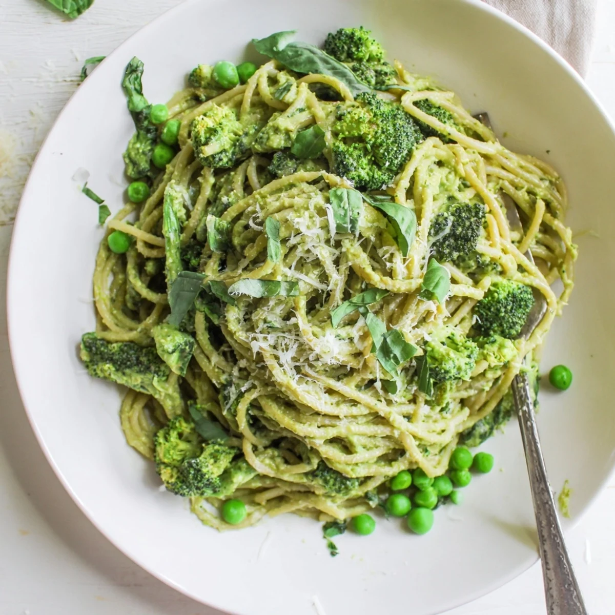 A family-style platter of Veggie Smuggler Avocado Pasta garnished with lemon zest and basil leaves.