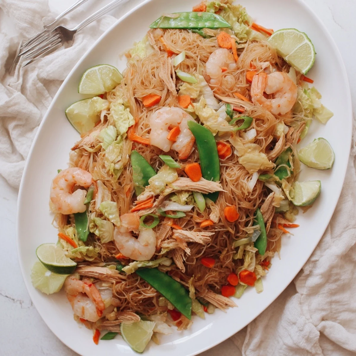Steaming serving of Filipino Pancit Bihon rice noodles stir-fried with juicy shrimp and shredded cabbage