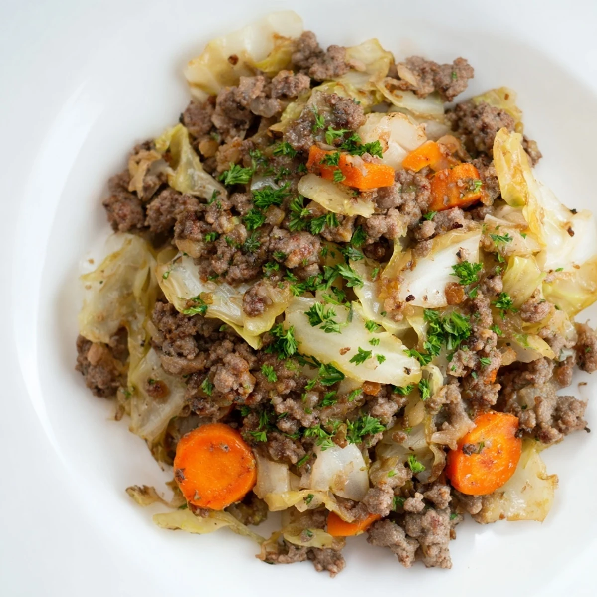 Comforting one-pan Irish ground beef and cabbage dish steaming hot with tender vegetables and beef broth