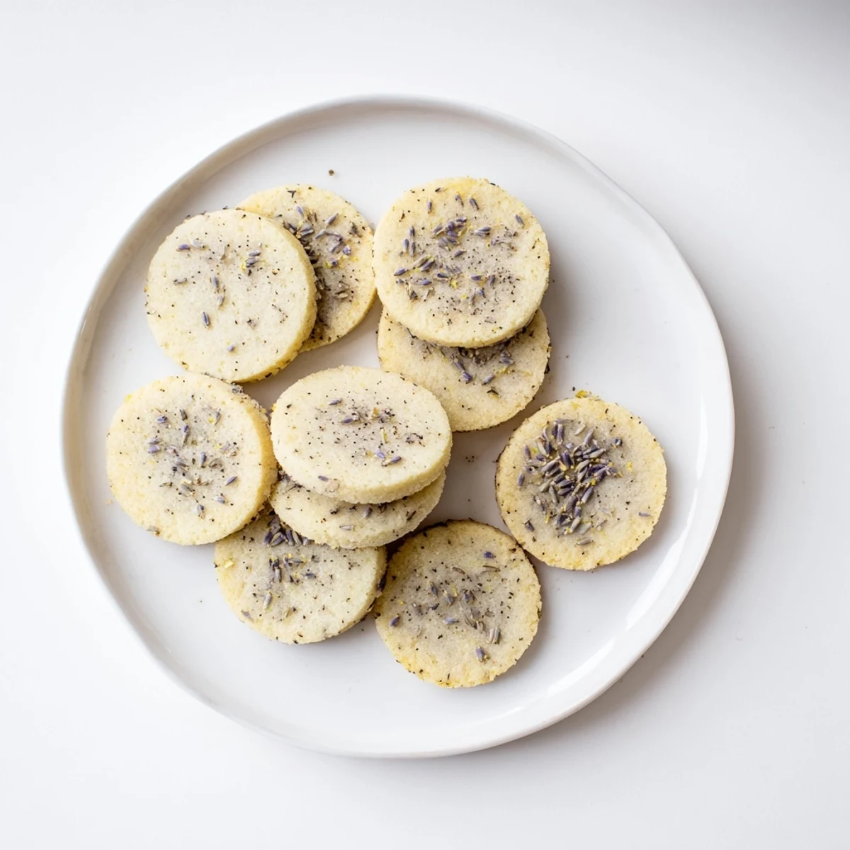Soft buttery lemon lavender cookies arranged on a white ceramic plate for afternoon tea
