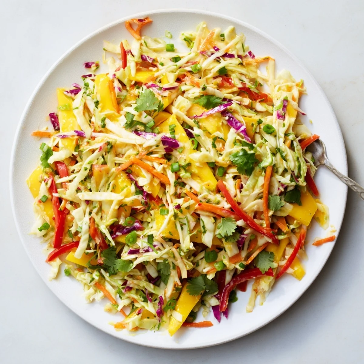 Fresh mango slaw bowl with red green cabbage carrots cilantro garnish