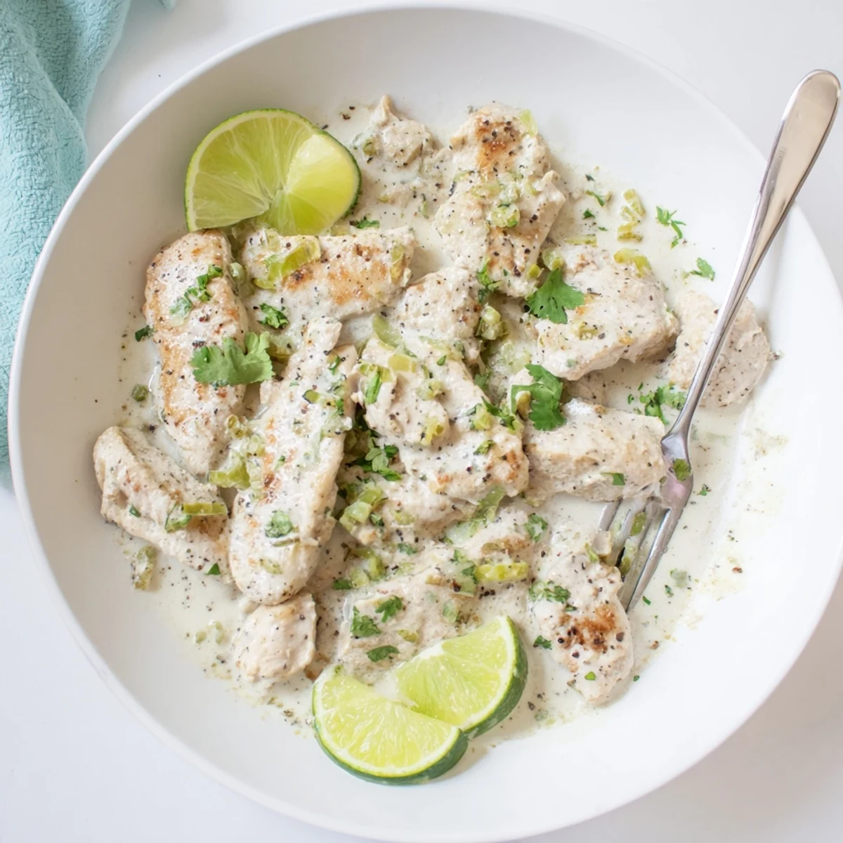 Juicy coconut lime chicken plated over white rice drizzled with thick creamy cilantro sauce