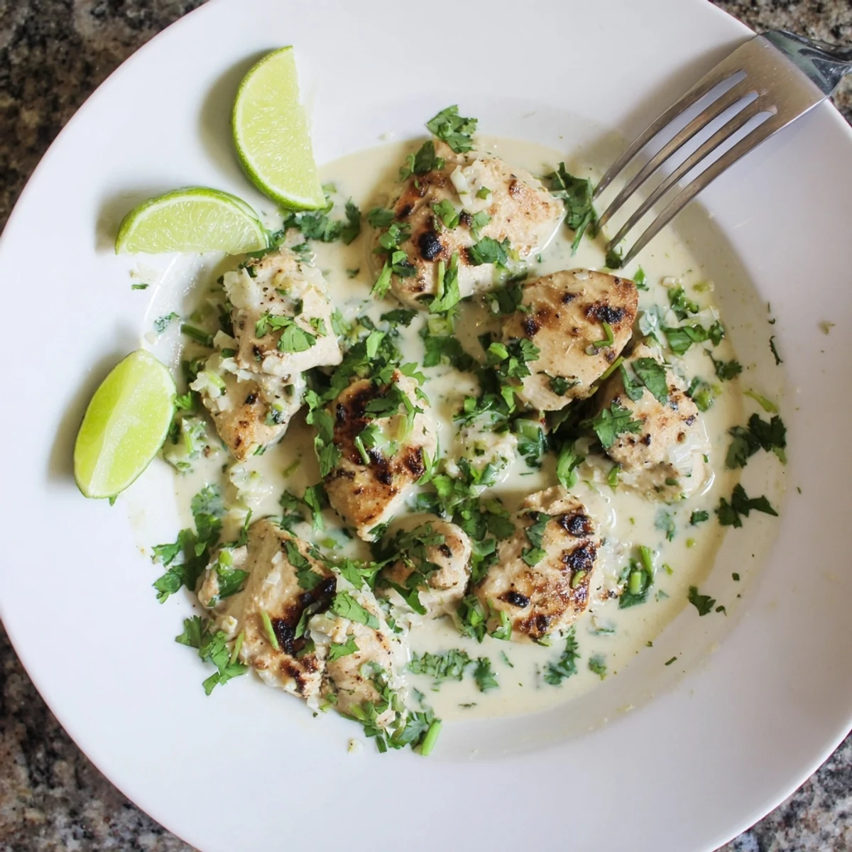 Tender chicken breasts simmered in rich coconut milk sauce with lime wedges and green onions