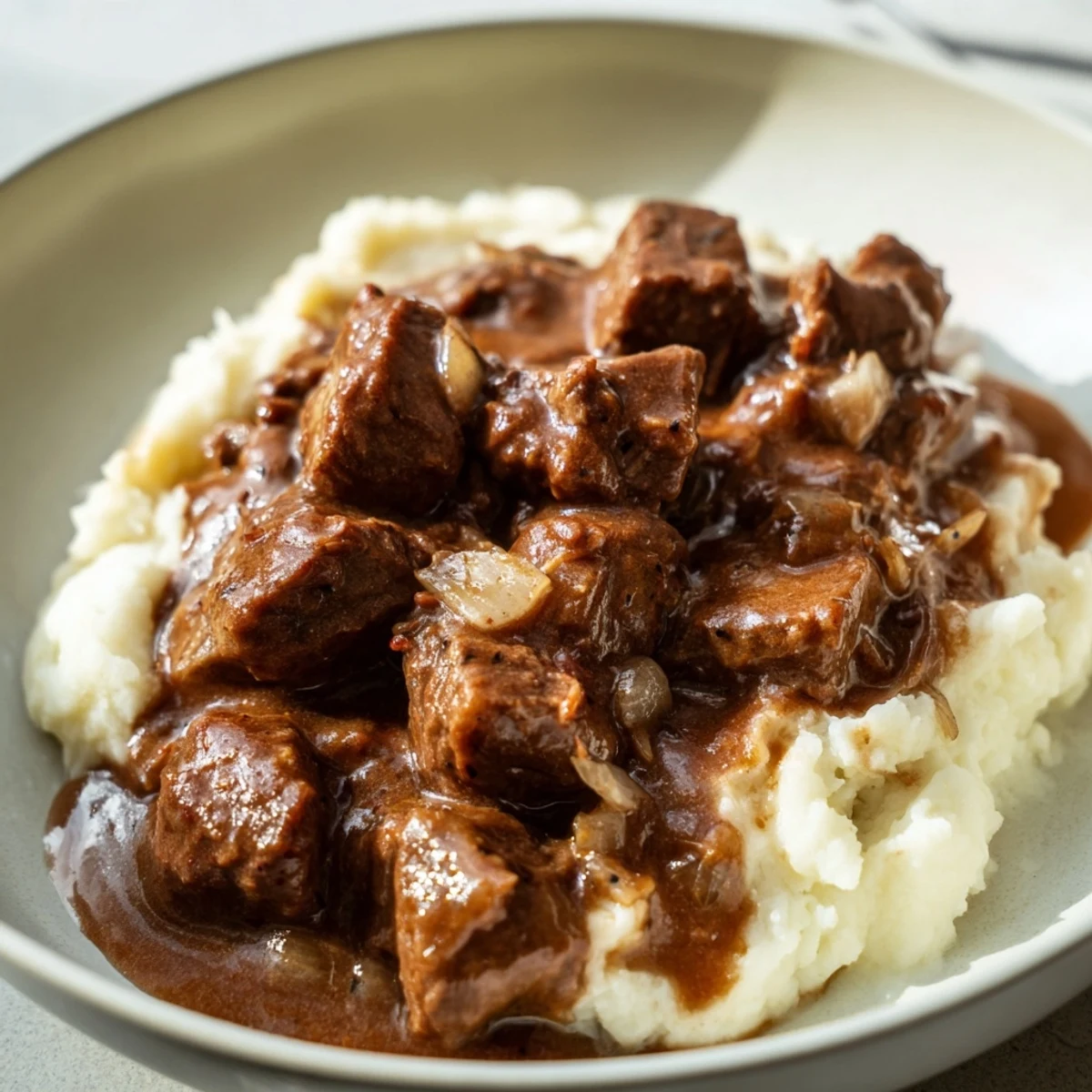 Hearty slow cooker beef tips and gravy plated with buttery noodles for a satisfying dinner