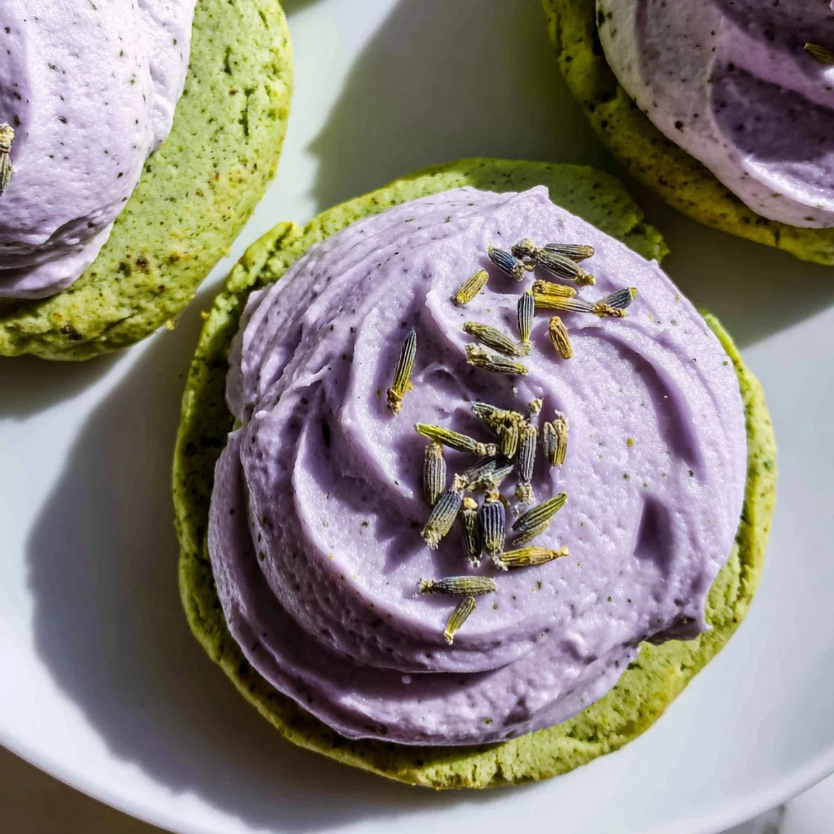 Elegant matcha sugar cookies featuring smooth lavender frosting arranged beautifully for an afternoon tea spread