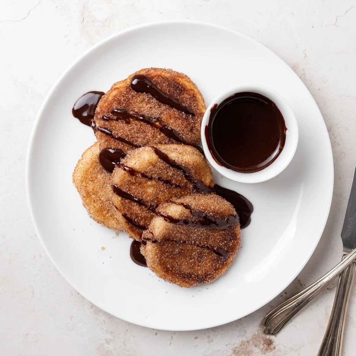 Golden Spanish Churro Pancakes dusted with cinnamon sugar served with warm dipping chocolate