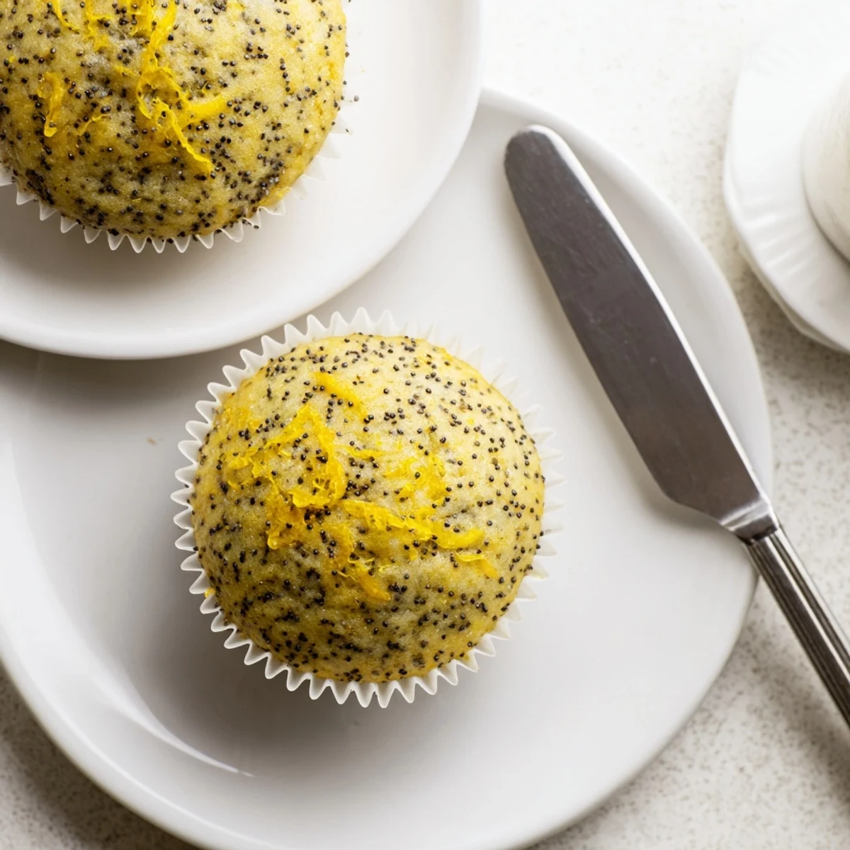 Golden lemon poppy seed muffins with domed tops fresh from the oven on a cooling rack