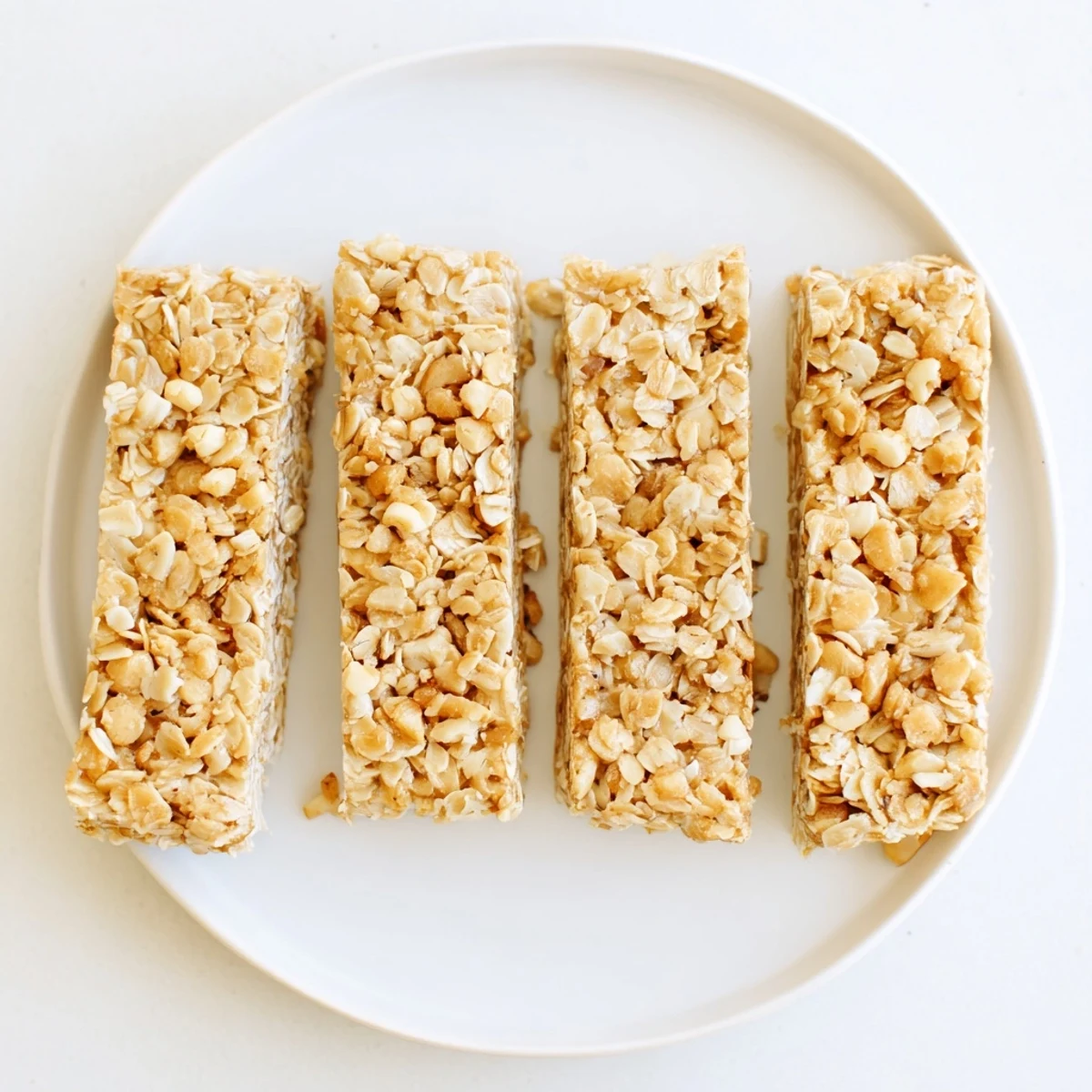 Thick no bake apple peanut butter granola bars cut into squares on a parchment-lined surface