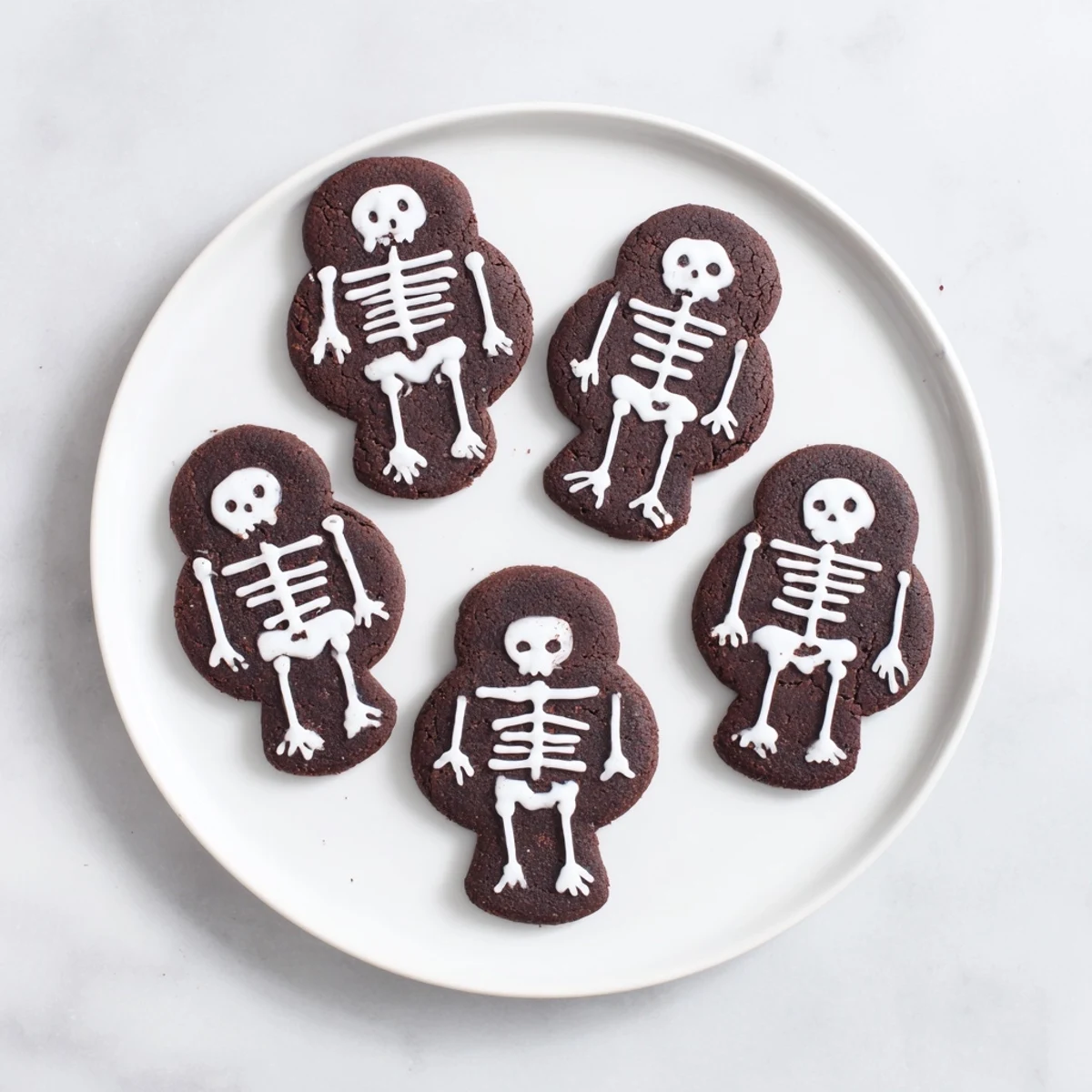 Chewy spiced chocolate cinnamon skeleton cookies arranged on a festive Halloween dessert platter