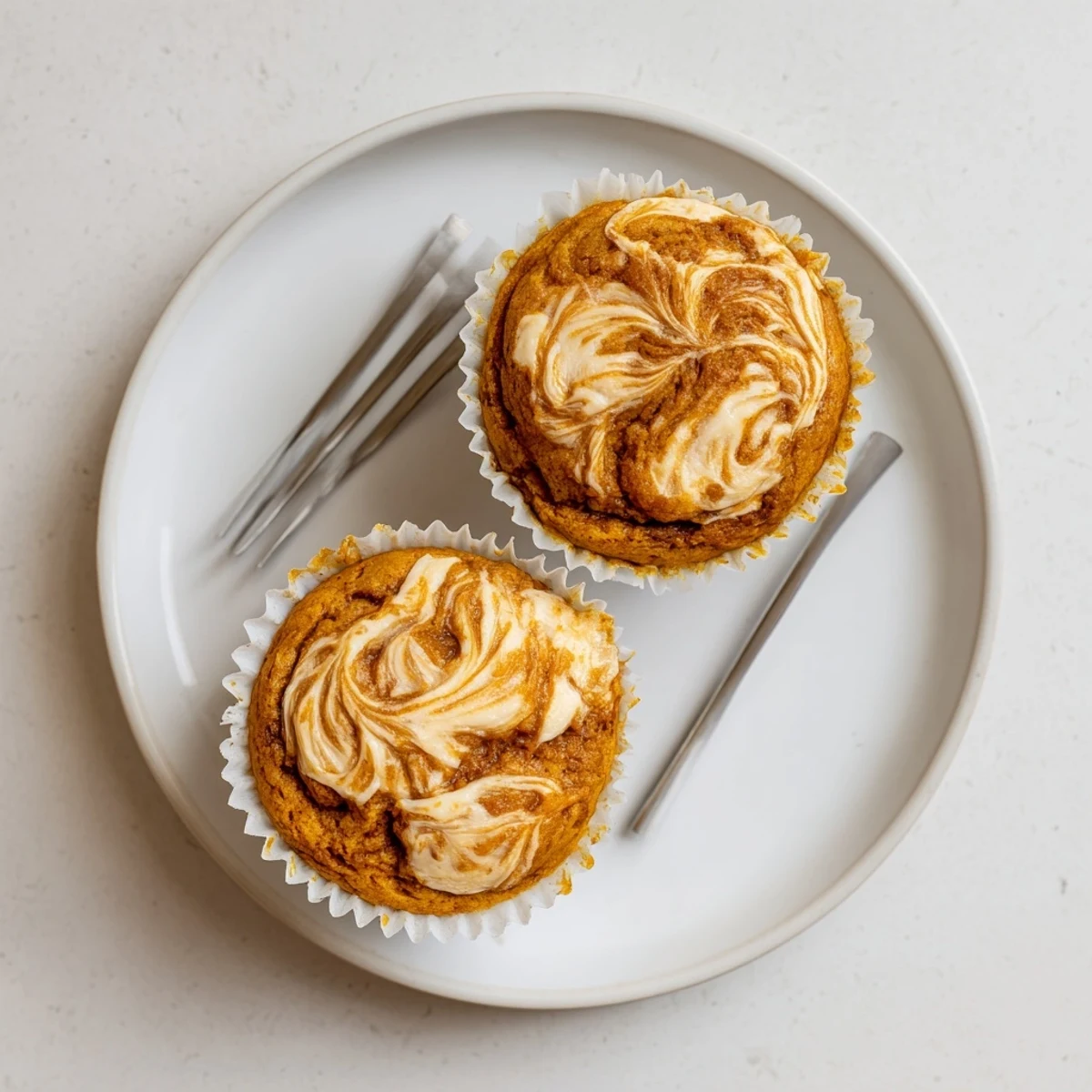 Golden chai pumpkin cheesecake muffins with swirled spiced cream cheese filling