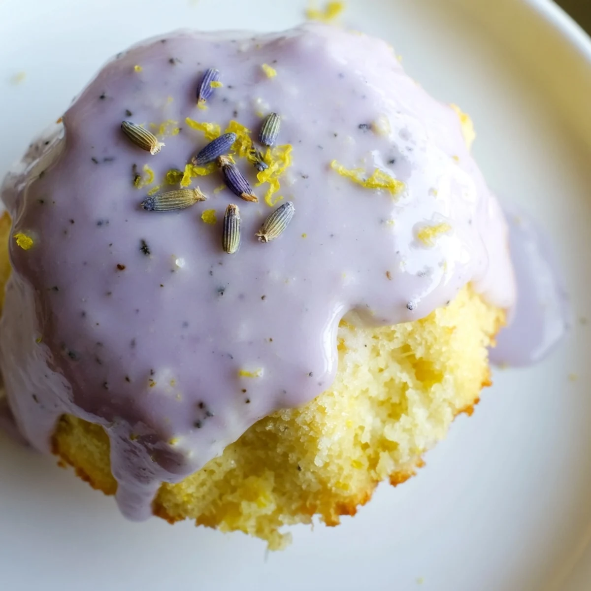 Golden mini lemon cakes with lavender glaze dripping down their tender crumb