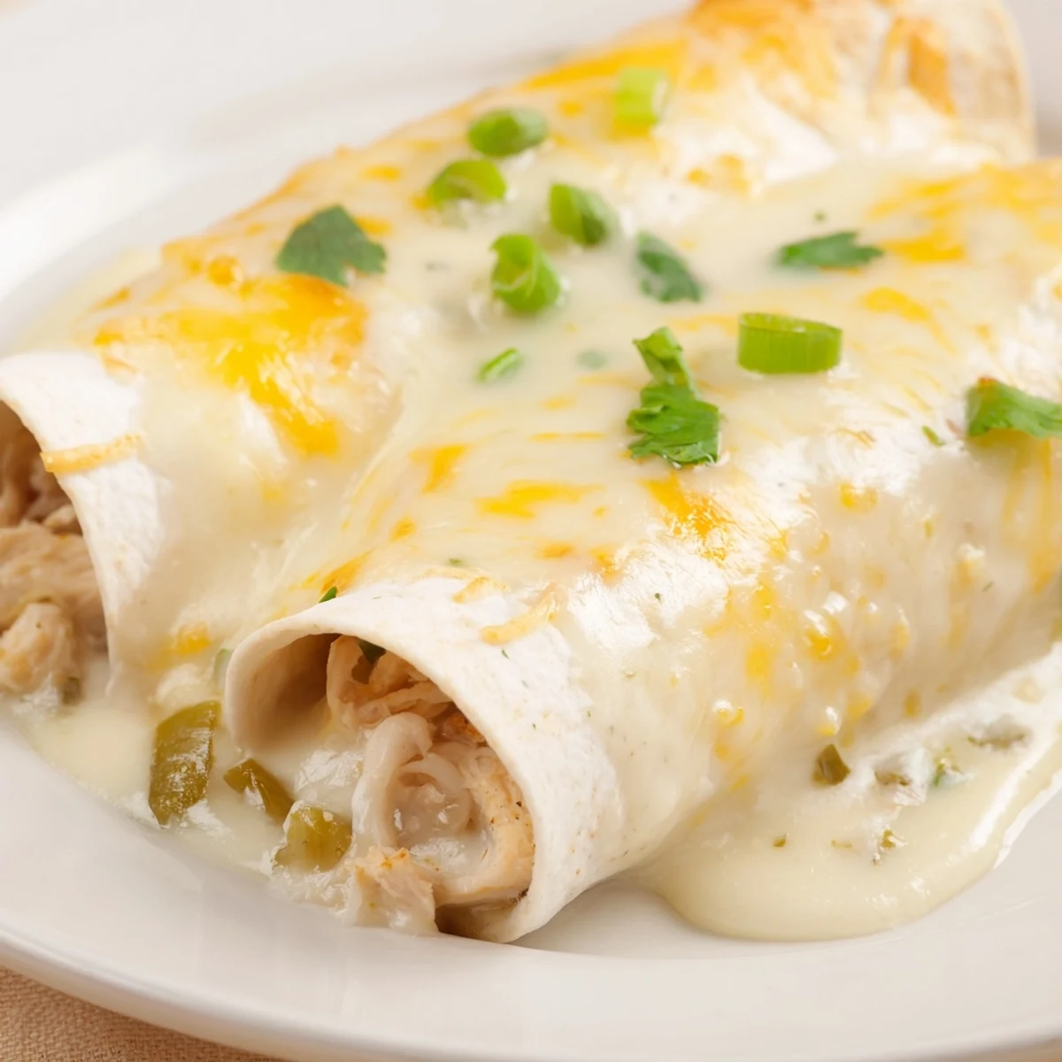 Hot Creamy White Chicken Enchiladas with velvety sauce, ready for family dinner