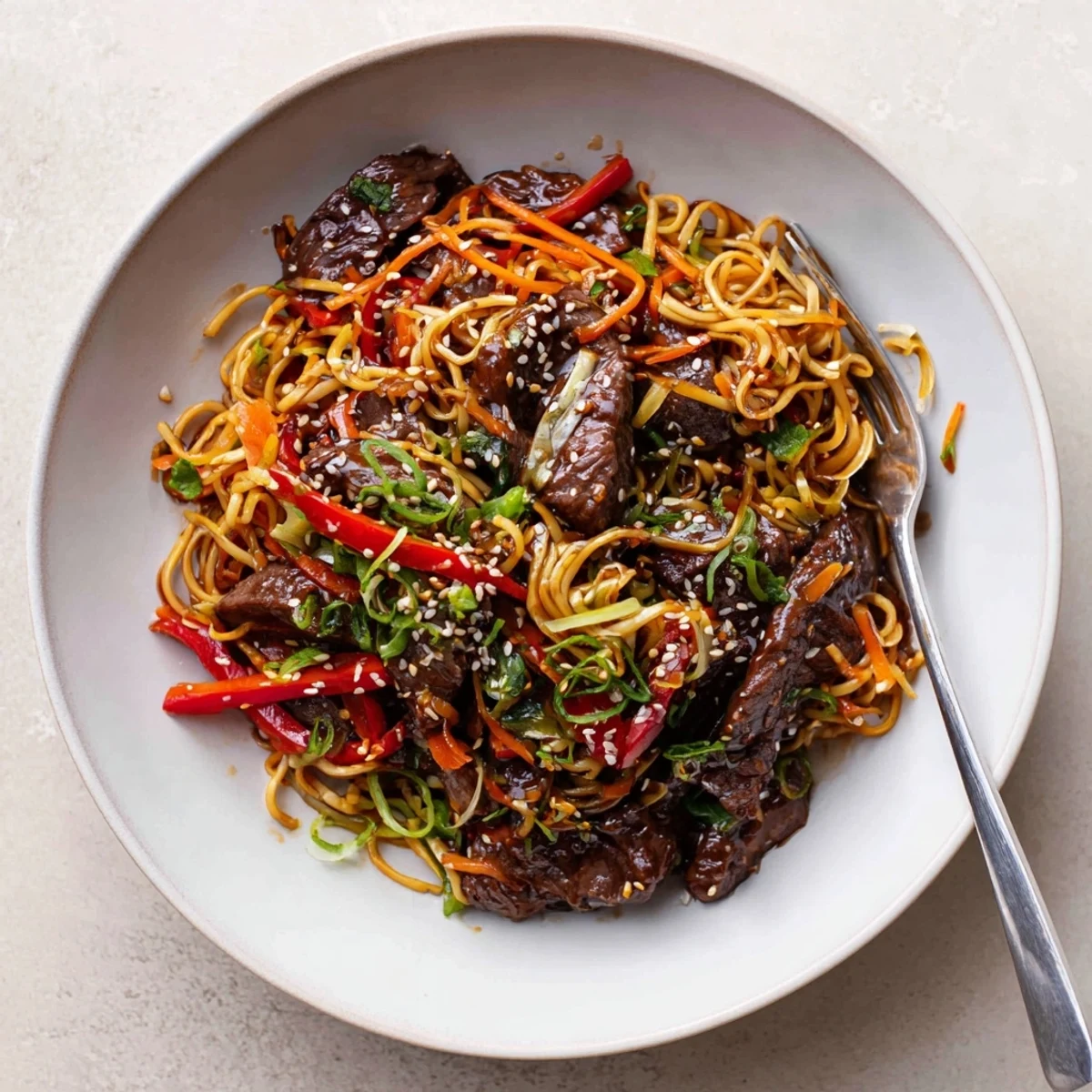 Bowl of Sticky Beef Noodles steaming, chewy strands, bright bell pepper slices