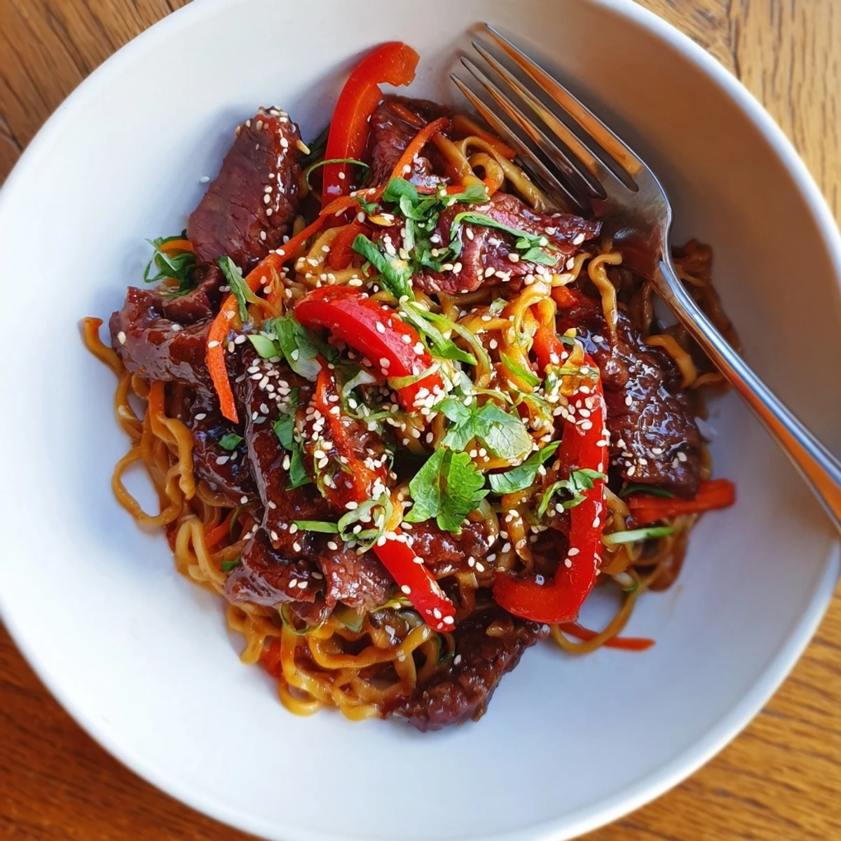 Sticky Beef Noodles tossed in glossy hoisin sauce, topped with toasted sesame