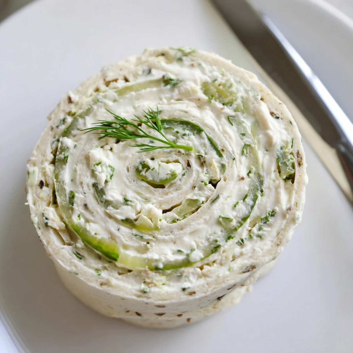 Party-ready Pickle Dip Pinwheels stacked on board, creamy tang and green onions