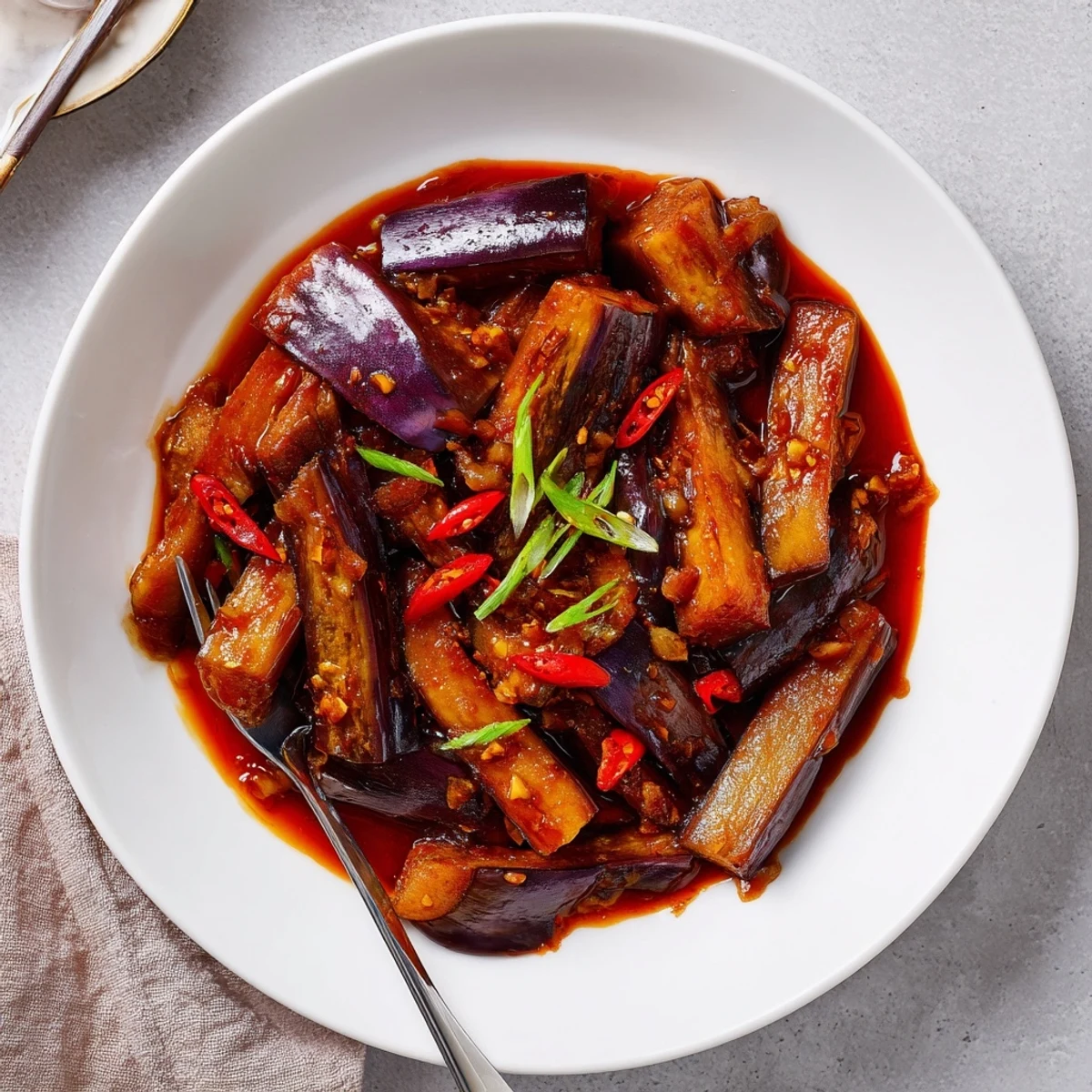 Sichuan Style Braised Aubergines served steaming from wok, sesame aroma, spicy bite