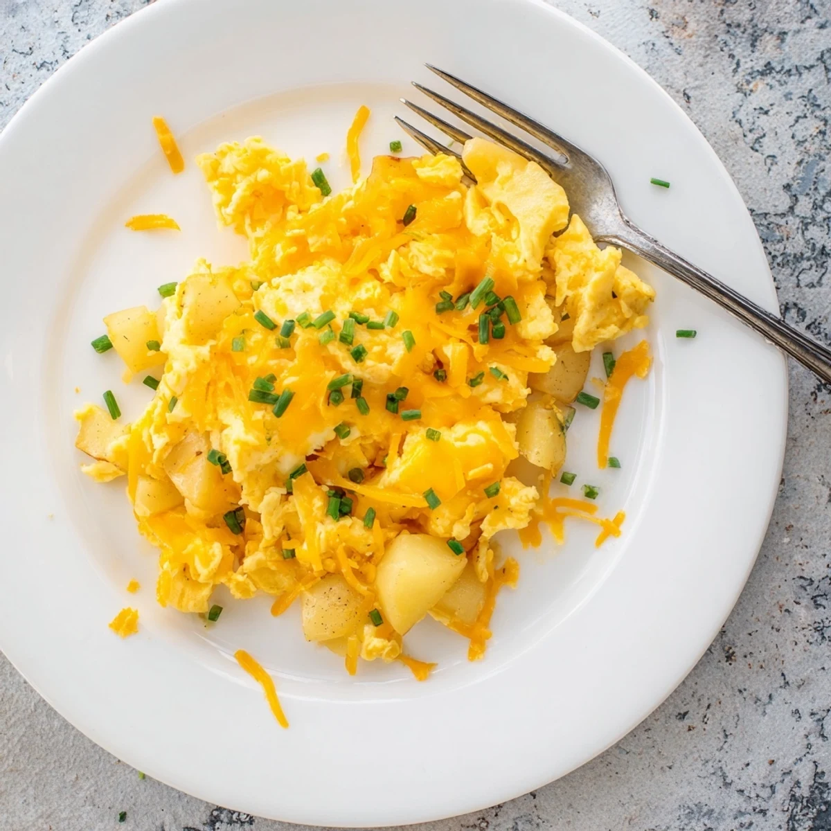 Hearty breakfast skillet of fluffy scrambled eggs with tender diced potatoes and gooey melted cheese