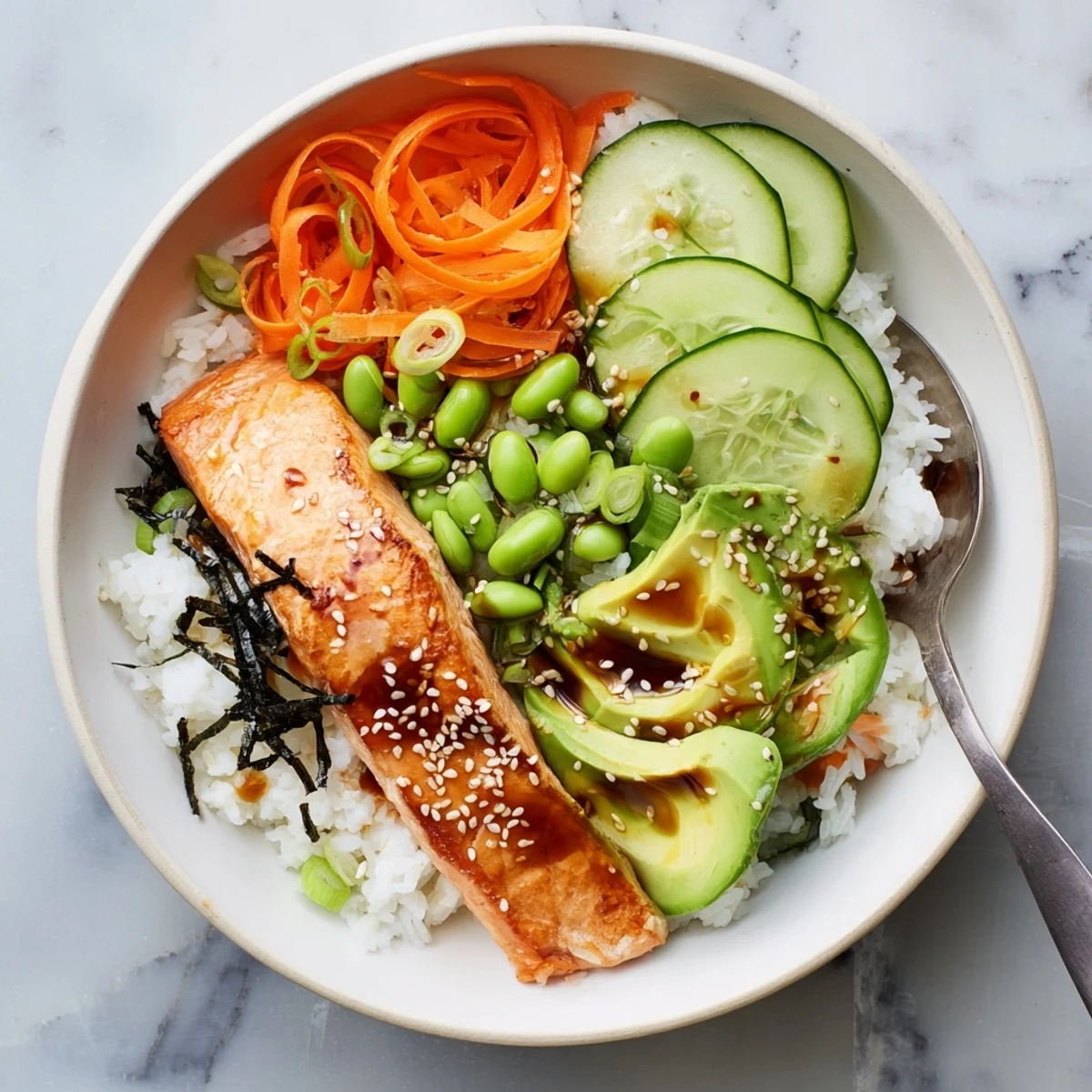Golden crispy salmon fillet with crunchy skin rests over fluffy white rice in a bowl