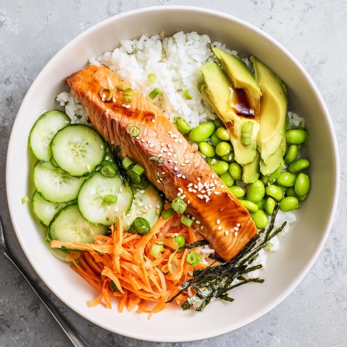 Asian-inspired crispy salmon and rice bowl featuring edamame carrots scallions and tangy ginger glaze