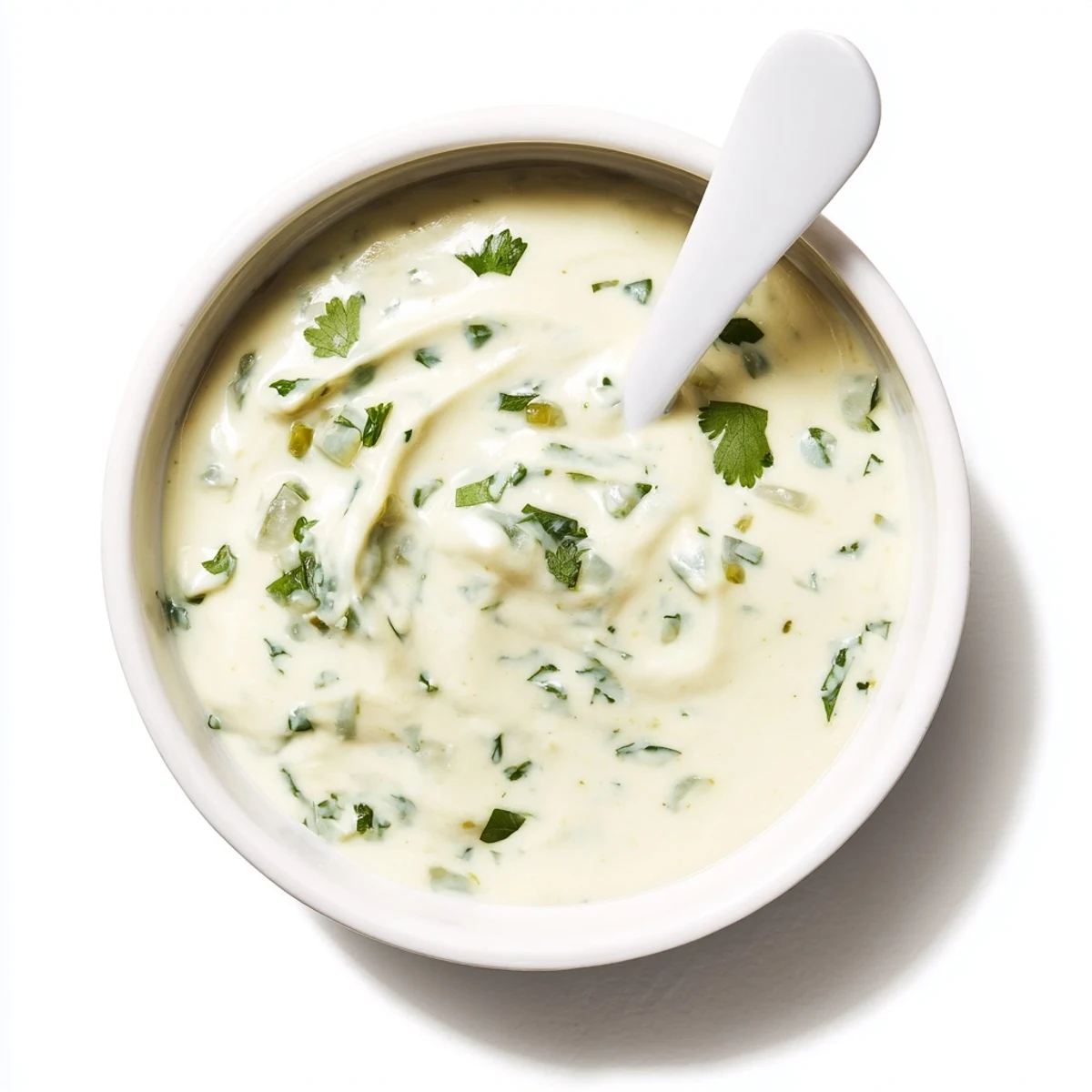 Creamy white Mexican sauce drizzled over crispy fish tacos with fresh cilantro garnish