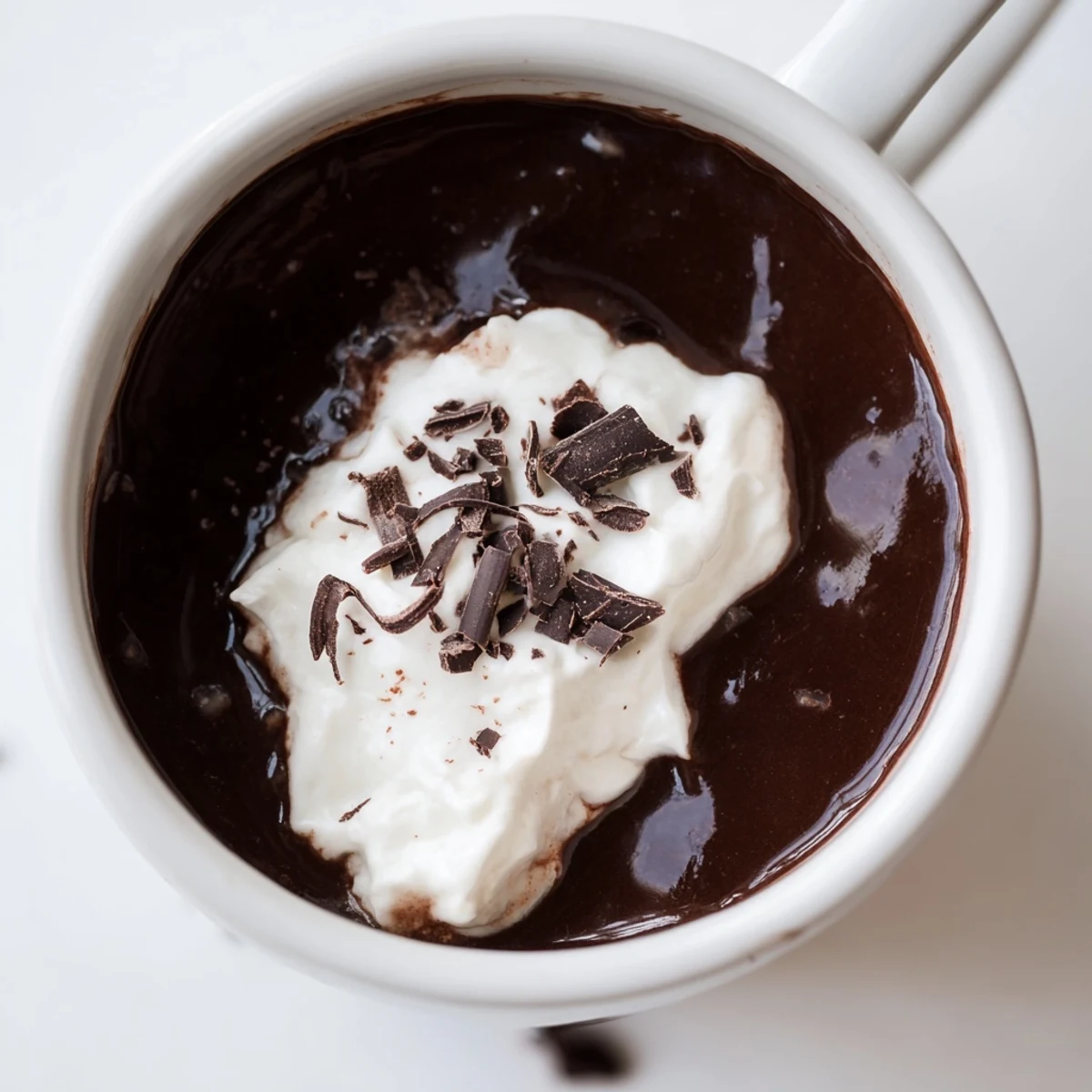 Rich creamy keto hot chocolate poured into two mugs with whipped cream topping