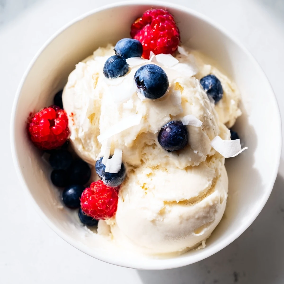 Vegan healthy nice cream recipe swirled with mixed berries in a chilled bowl garnished with fresh fruit