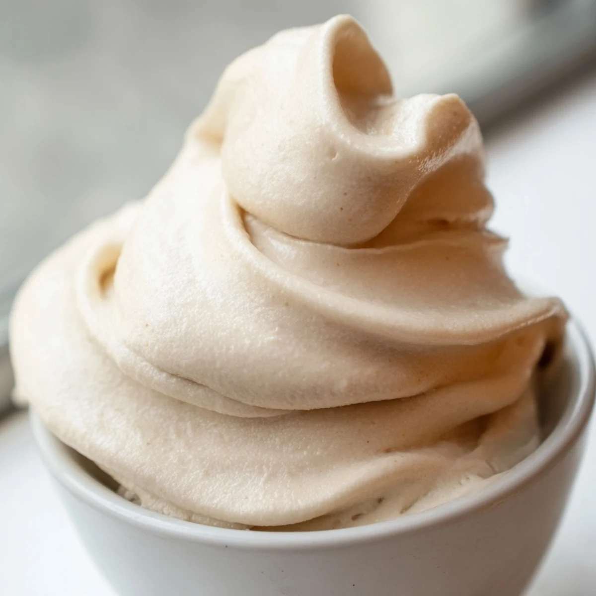 Frozen banana nice cream scooped into serving bowls with a smooth soft serve texture