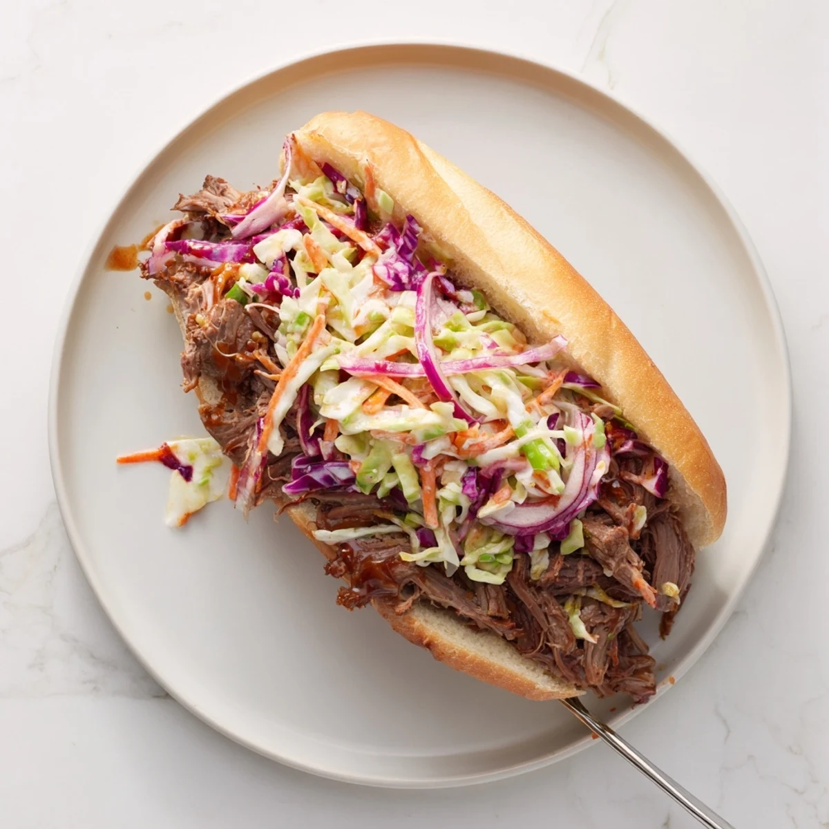 Homemade smoky BBQ beef sandwiches topped with crisp tangy coleslaw for perfect texture contrast