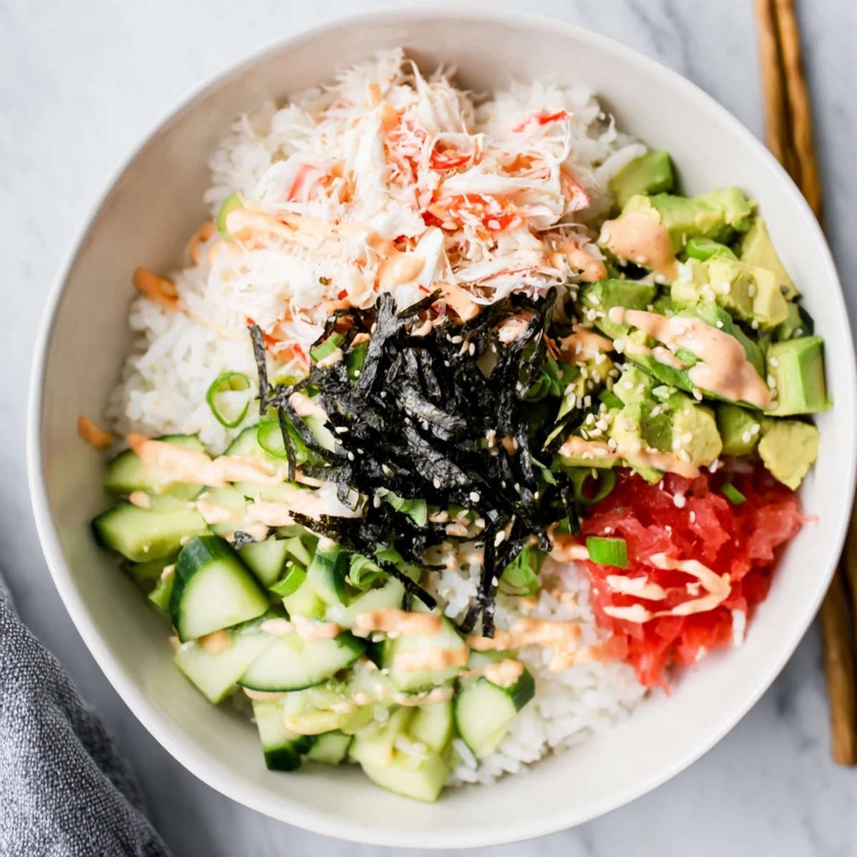 Deconstructed California roll sushi bowl featuring seasoned rice topped with fresh avocado and nori strips