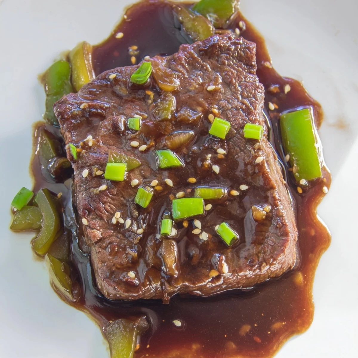 Juicy seared Asian inspired cube steak topped with green onions and sesame seeds