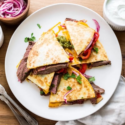 Crispy steak quesadillas sliced open revealing tender beef and gooey cheese filling